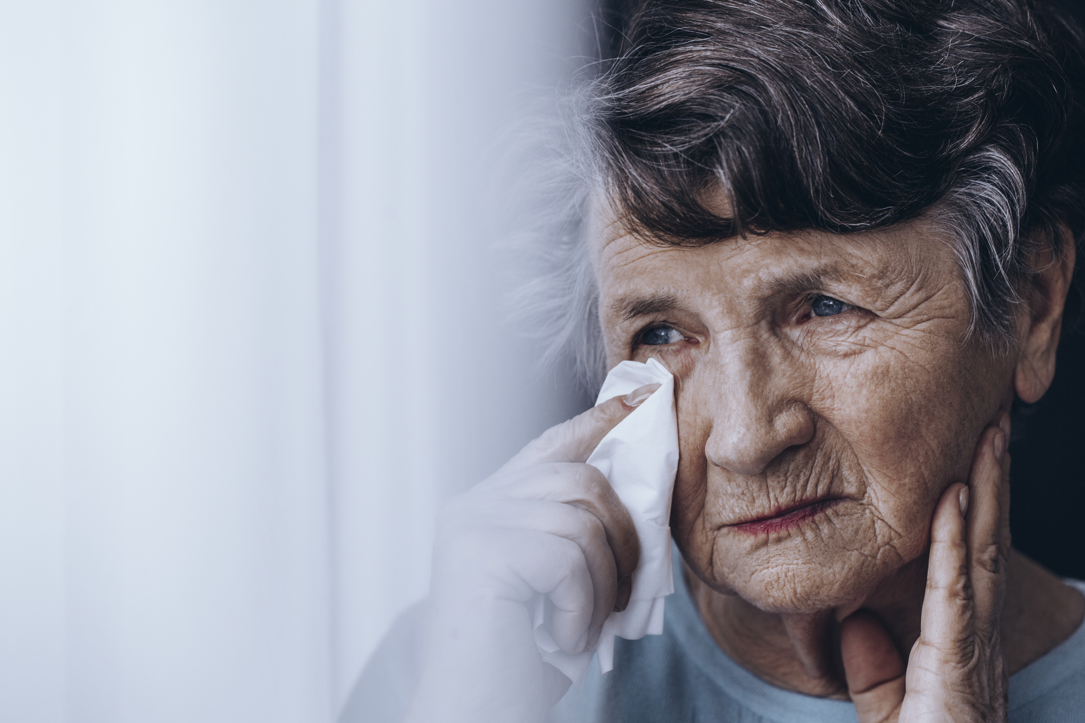 elder woman wiping tears away